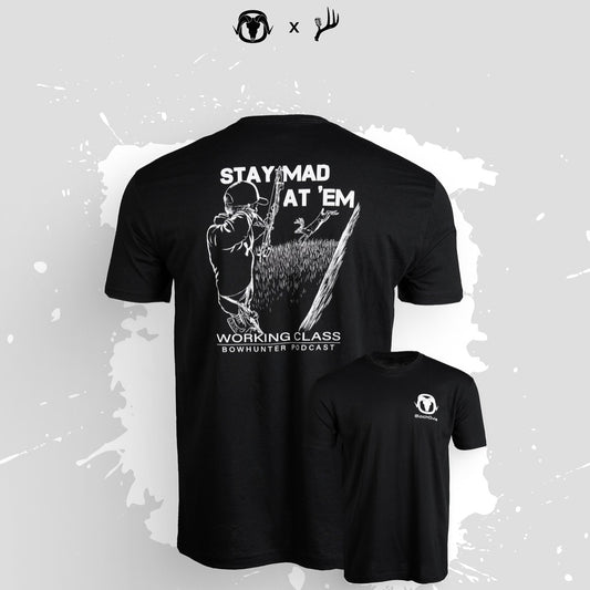Black short-sleeve t-shirt shown from the back and front on a light gray background with white paint splatter. The back has a large white graphic of a bowhunter aiming a bow, with the text 'STAY MAD AT 'EM' and 'WORKING CLASS BOWHUNTER FIDOCAST'.