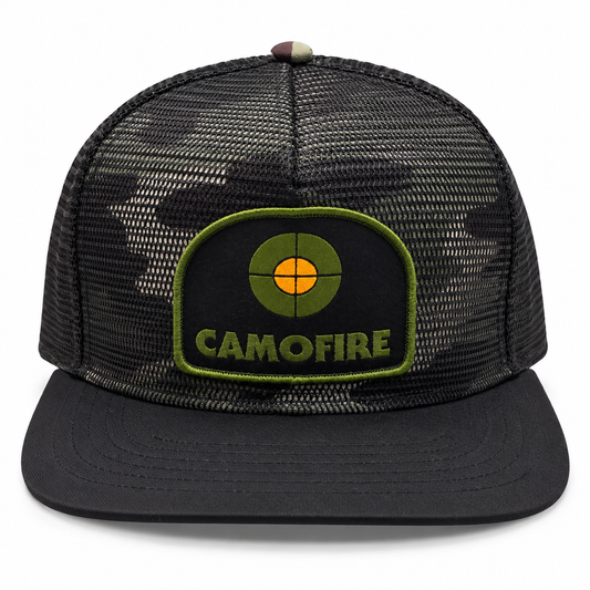A black trucker cap with a dark camouflage mesh back and a black flat brim, featuring a green and orange embroidered patch on the front with the text 'CAMOFIRE'.