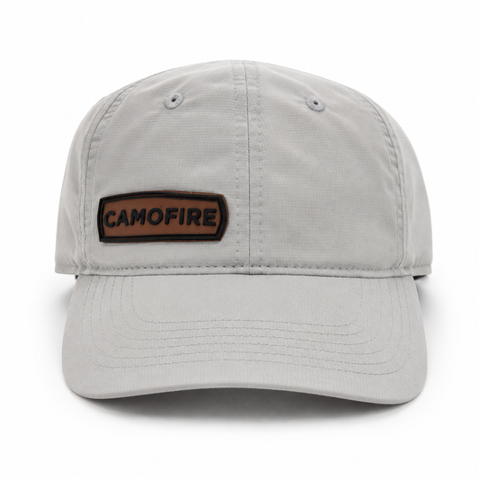 A light gray structured baseball cap with a brown rectangular patch on the front that reads 'CAMOFIRE' in black letters, shown on a clean white background.