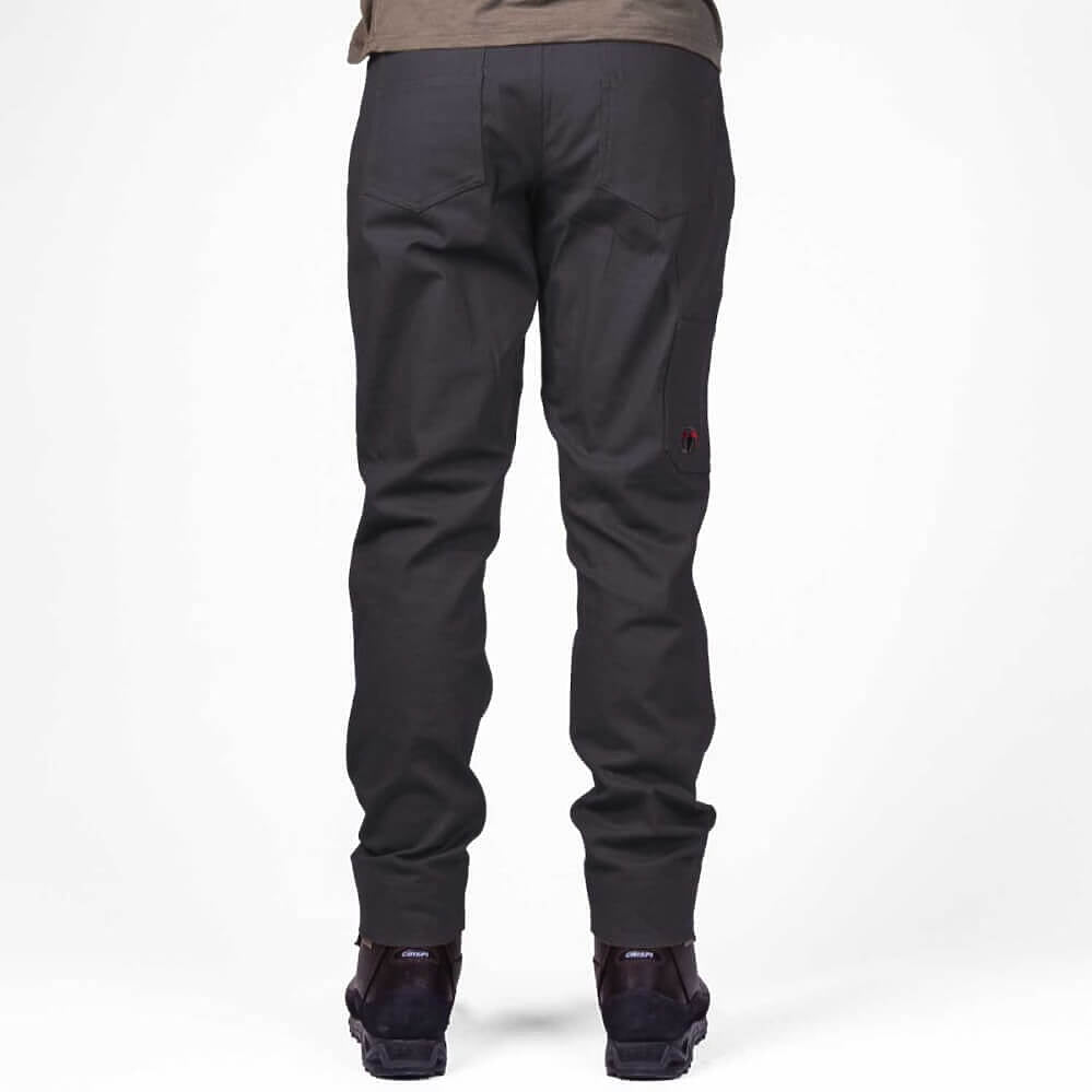 Rear view of a person wearing dark charcoal gray technical pants and dark boots against a clean white studio background.