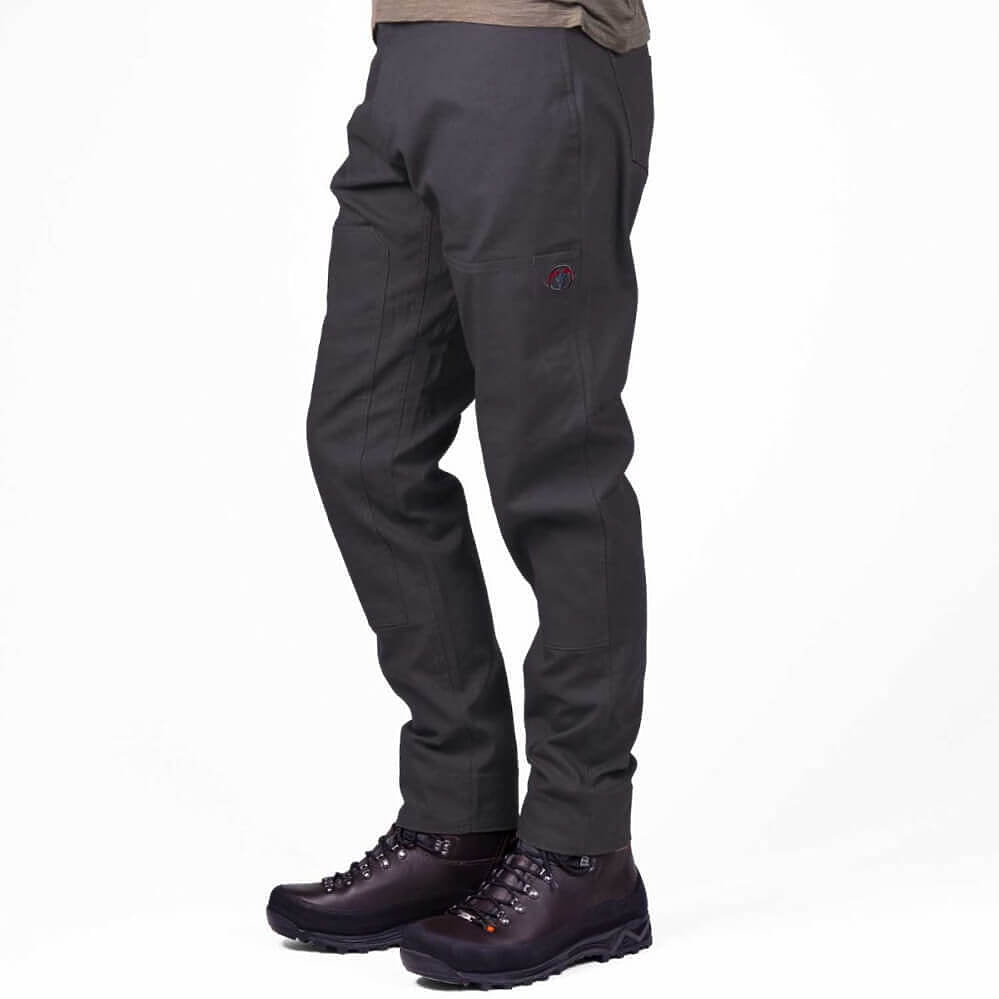 A person shown from the waist down wearing dark charcoal gray technical pants and dark brown hiking boots against a plain white studio background.