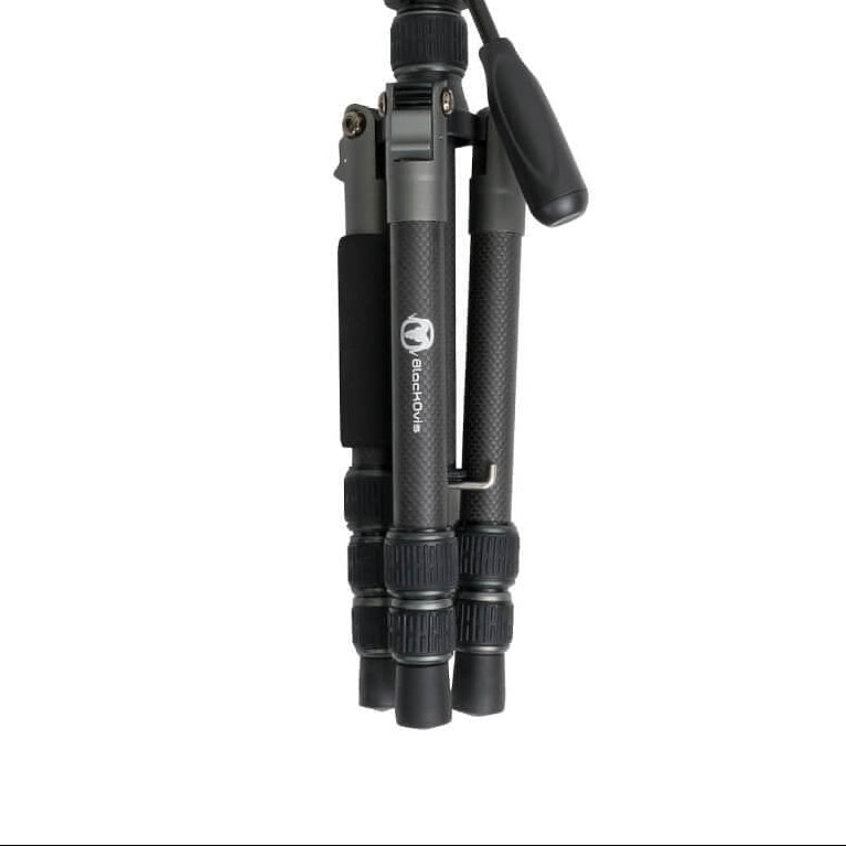 A black and dark gray tripod with a ball head and carrying handle, shown folded against a plain white background.