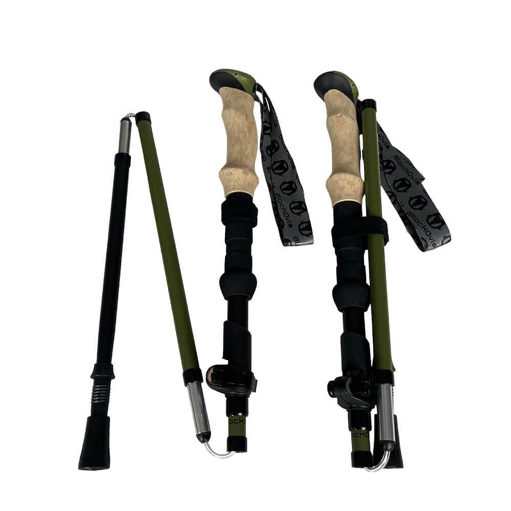 Four folding hiking poles arranged on a plain white background, showing both assembled and collapsed views. The poles are olive green with black sections, silver metal tips, and light tan wood-look handles.