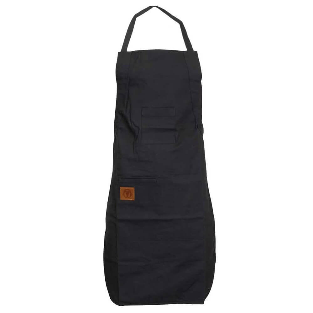 A black bib apron with a neck strap and waist ties, featuring a front pocket and a small brown leather brand patch on the lower left side, shown against a plain white background.