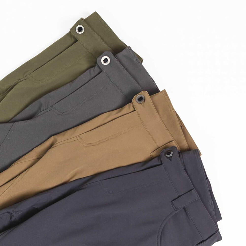 Four pairs of folded pants in different colors (olive green, charcoal gray, tan, and dark charcoal) arranged diagonally on a white background.