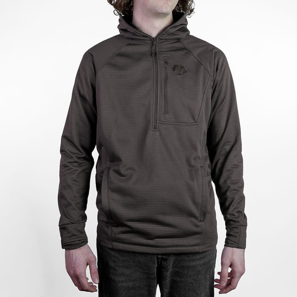 A man wearing a dark brown textured quarter-zip pullover hoodie with a small embroidered logo on the left chest, shown from the neck down against a plain white background.