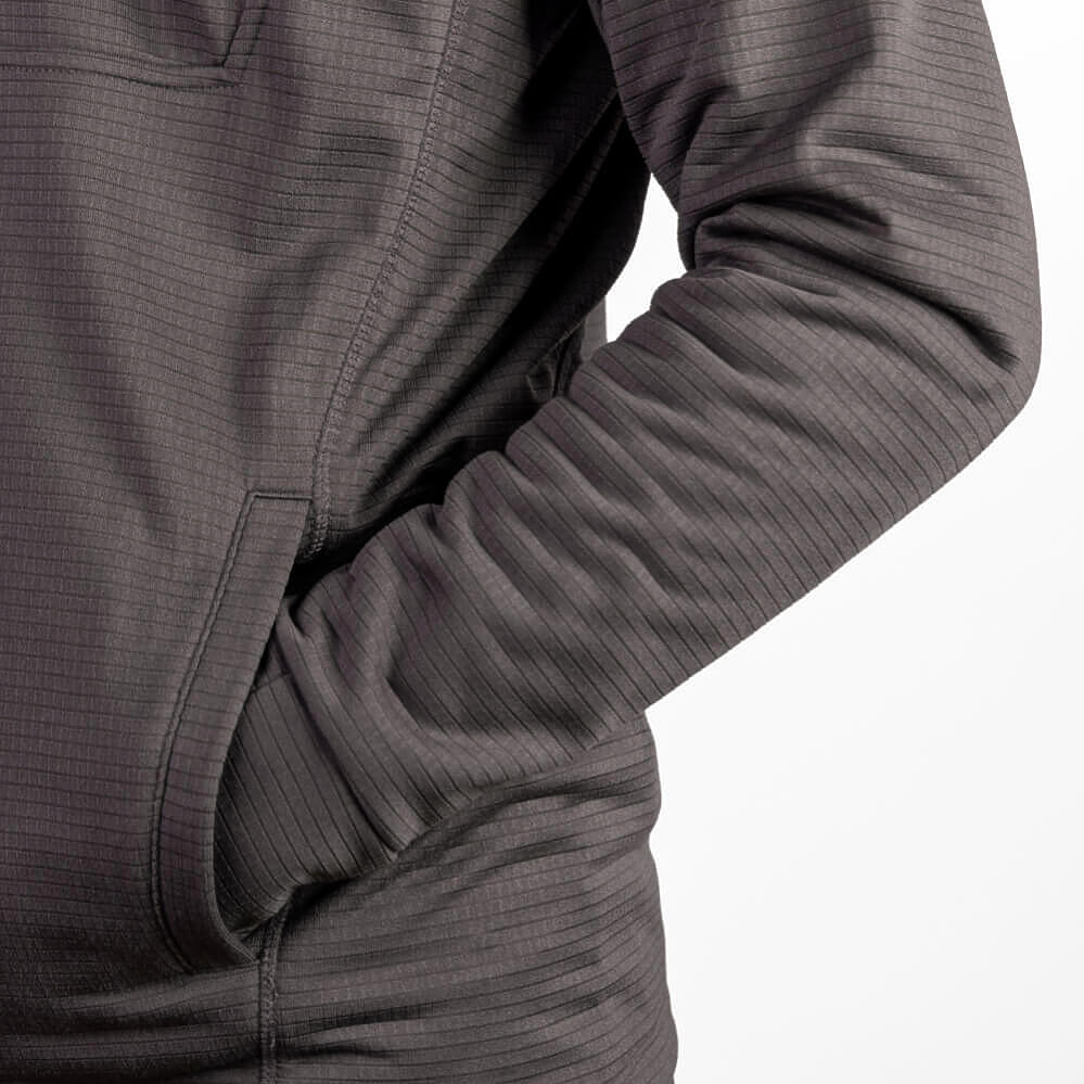 Close-up of a dark gray ribbed athletic pullover jacket with a zippered pocket, shown on a model against a white background.